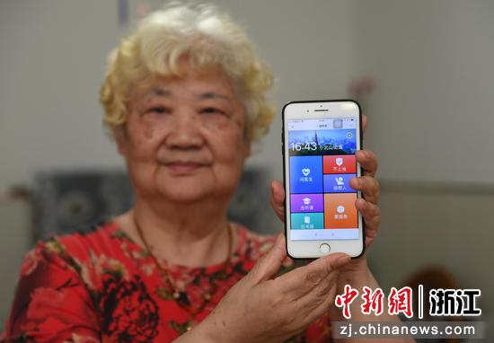 一位老人在展示西湖区北山街道手机端适老化服务平台。  王刚 摄