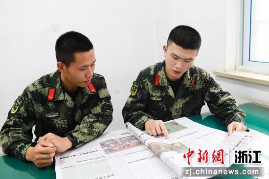 官兵们坐在一起读报  陈业国 摄