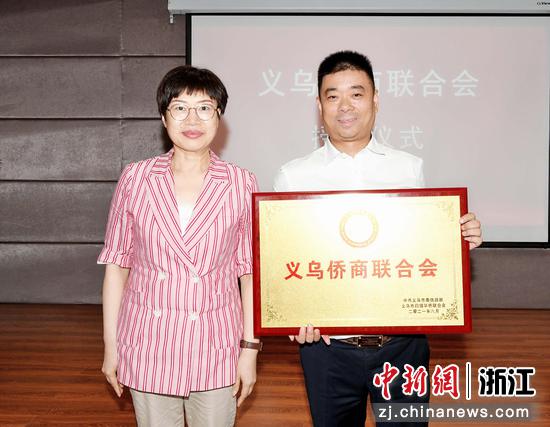 义乌市委常委、统战部长董利明（左）为义乌侨商联合会授牌。王伟丽 摄