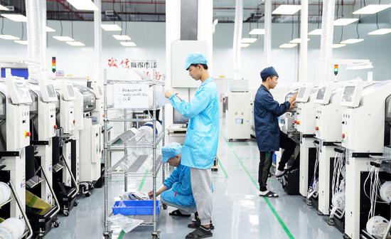 在贵阳臻芯科技有限公司生产车间，工人正在进行生产作业