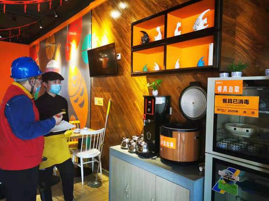 国网新疆电力公司工作人员在餐饮店推广能效账单讲解全电厨房安全知识。李明威 摄