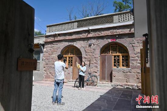8月25日，“90后”夫妻高磊和王美娜正在石窑民宿前录制短视频。(资料图片) 中新社记者 翟羽佳 摄