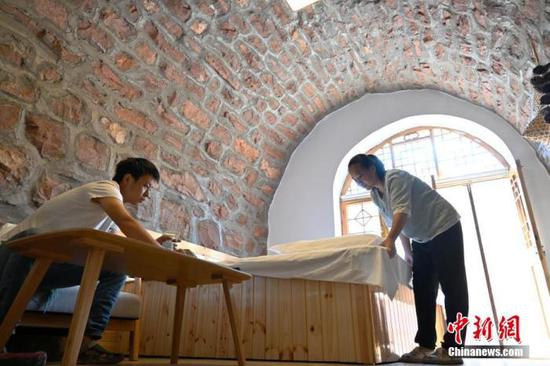 8月25日，“90后”夫妻高磊和王美娜正在收拾他们改建的石窑民宿。(资料图片) 中新社记者 翟羽佳 摄
