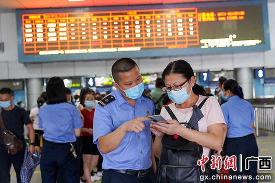 图为湛江车站客运人员帮助旅客利用手机进行退票改签。李超宇 摄