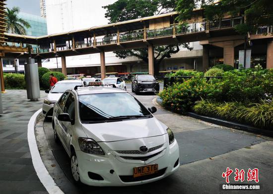 当地时间9月2日，菲律宾首都马尼拉CBD马卡蒂绿带商圈，出现出租车排队待客现象。马尼拉目前仍在实施“修订版加强社区隔离”(MECQ)，但已逐步增加部分行业开放度，出租车按照卫生要求恢复运营。 中新社记者 关向东 摄