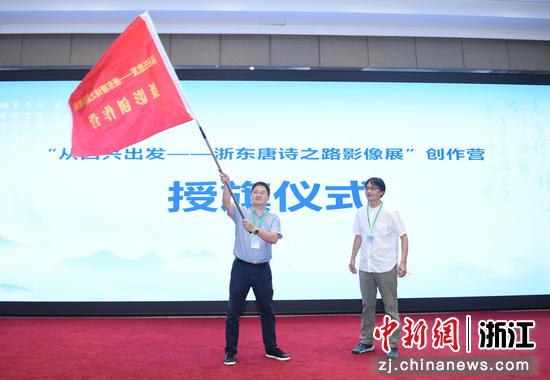 浙江省摄影家协会副主席王芯克（右）为摄影创作营授旗。王刚 摄