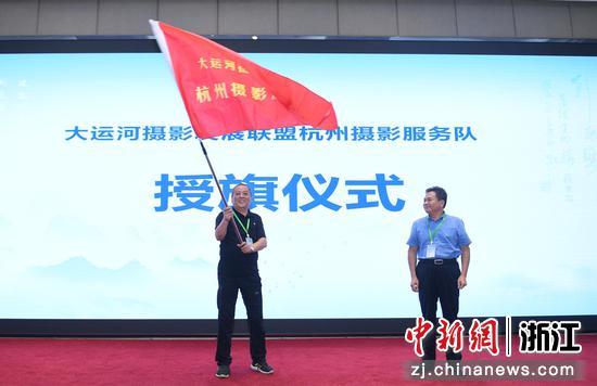 　　浙江省摄影家协会副主席、杭州市摄影家协会主席张友国为大运河摄影发展联盟杭州摄影服务队授旗。王刚 摄