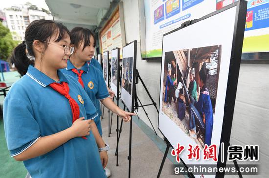 9月7日，贵阳市第二十七中学的学生正在参观《贵州少数民族服饰图片展》。