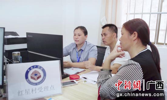 不动产登记工作人员在南宁市邕宁区百济镇红星村受理点为群众办证。林思婷摄