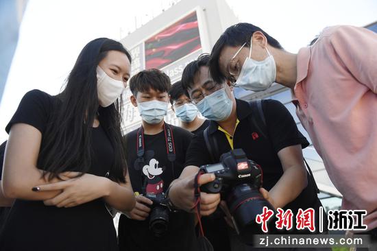 　　中国新闻图片网副总编杜洋（右二）和杭州市摄影艺术学会航拍专业委员会委员张劲松（右一）在指导学员。 许少峰供图
