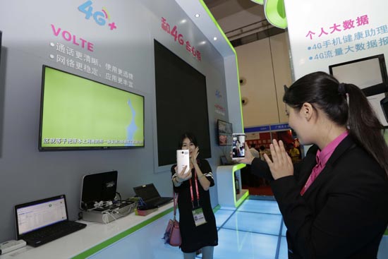 在第12届中国—东盟博览会上，到广西移动展台参观体验的客商正在与工作人员体验VoLTE高清语音。