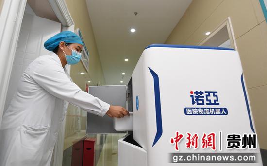9月14日，贵阳市妇幼保健院南明分院药房的药师正在给诺亚医院物流机器人装载药品。
