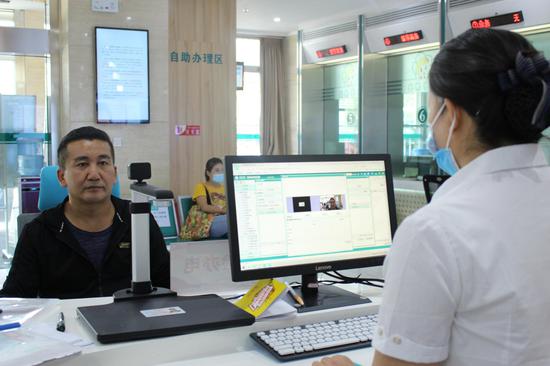 9月16日，乌鲁木齐市居民阿不杜卡德·阿不都热合曼在北京路营业厅使用“刷脸办电”办理过户业务。李翔楠 摄