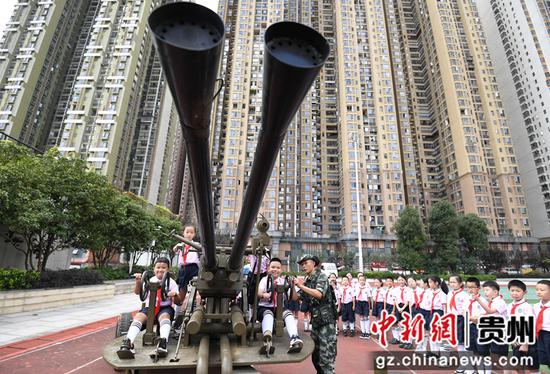 9月18日，教官正在给贵阳市南明区花果园第三小学的学生讲解双37高射炮的构造和用途。