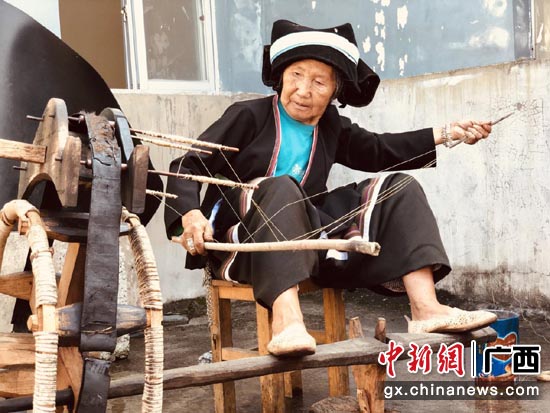 德峨镇龙德峨村龙洞大寨屯77岁的杨横奶在纺纱。