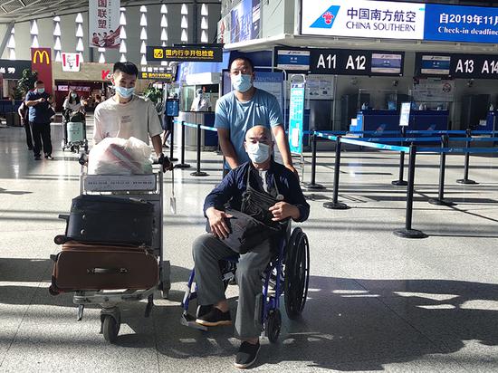 社区干部陈俊良和工作队队员李显强将王京海送至机场。