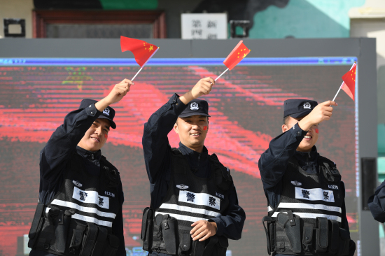 图为民警们挥舞国旗合唱歌曲《我和我的祖国》