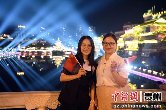 9月29日晚，人们在贵阳市南明河畔预演国庆灯光秀现场拍照留影。