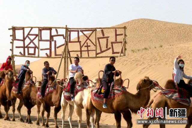 10月1日，游客在沙漠体验骆驼乘骑。汪志鹏摄 