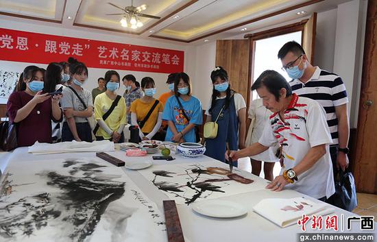 游客在钦州市老街区一家书画院观看画家作画。曾开宏 摄