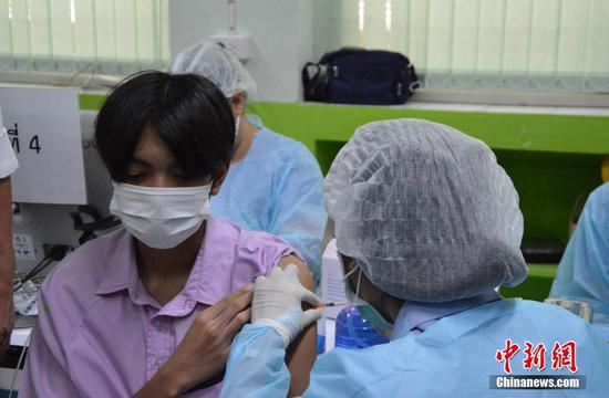 当地时间10月4日，泰国曼谷一名学生在当地一处接种点接种新冠疫苗。从当天开始，泰国政府大规模为12岁至18岁的学生接种新冠疫苗，以争取在11月开始的新学期能够恢复现场教学。 中新社发　 琳达 摄