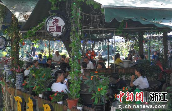 众多游客在杭州梅家坞村的农家乐品茶休息。 王刚 摄
