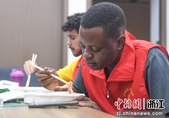 米莱（右）使用筷子吃中国菜。 王刚 摄