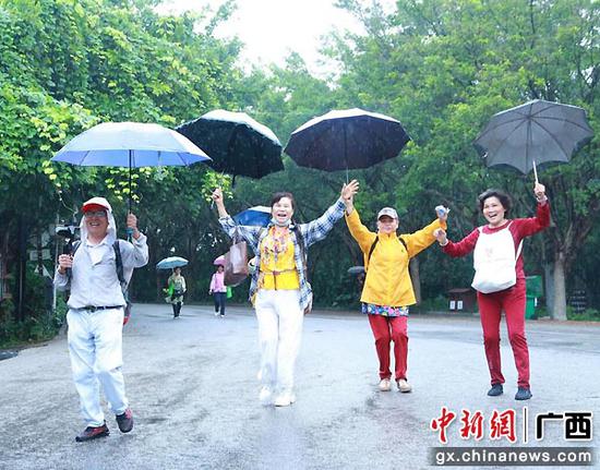 图为冒雨参加登高节的市民。南宁青秀山风景区 供图