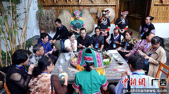 10月11日，参加广西都安瑶族自治县“三区”文化人才能力提升培训班的学员在品尝筛箕宴。高东风  摄
