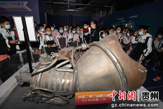 10月15日，学生们在2021全国科普日“中国飞天梦”中国航天科普巡展现场参观液体火箭发动机残骸实物。