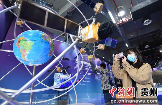 10月15日，一名参观者在2021全国科普日“中国飞天梦”中国航天科普巡展现场参观北斗三号全球卫星导航系统模型。