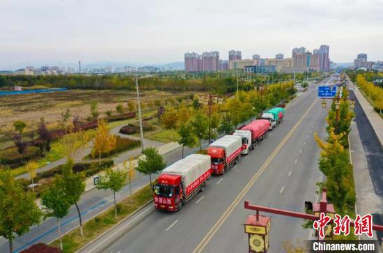 10月12日，阜康市装有150吨价值65万元物资的卡车准备就绪，开往山西受灾地区。　卢浩楠 摄