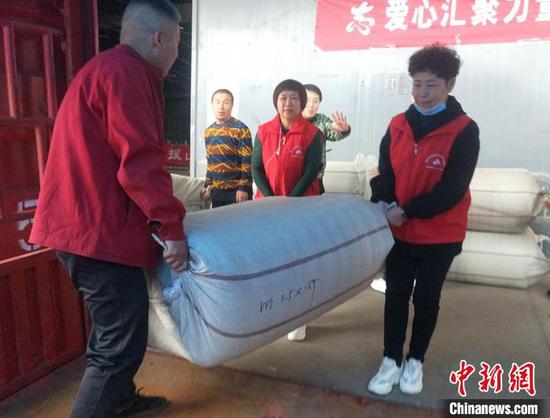 临汾市红十字会工作人员会将物资统一发放到受灾群众的手中。　齐琳洁 摄