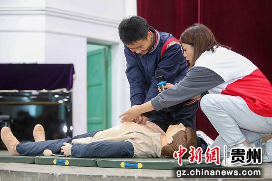 2021年10月19日，在贵州省铜仁市玉屏侗族自治县第一中学，红十字会工作人员在指导学生学习心肺复苏急救知识。