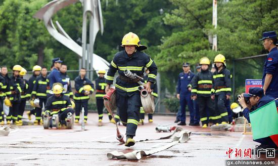 一名消防员正在进行一人三盘水带连接操项目比武。 吴小舒 摄