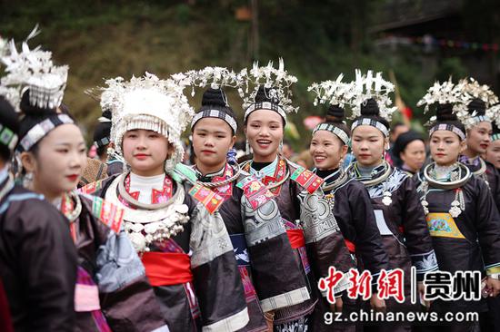 10月21日，在贵州省丹寨县扬武镇排莫村，苗族妇女在吃新节中整理银饰。