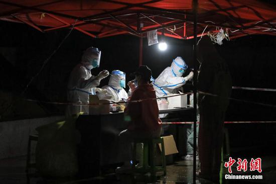 10月21日晚，贵州遵义市汇川区东方星园小区，医护人员在临时搭建的核酸检测点为居民做检测。 中新社记者 瞿宏伦 摄
