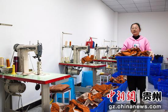 2021年10月19日，贵州省黔西市锦绣街道锦绣社区易地扶贫搬迁安置点花都鞋业加工车间，搬迁群众搬运鞋面半成品。
