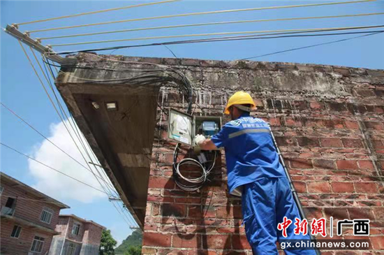 桂林移动技术人员为村民安装“平安乡村”产品。  广西移动  供图