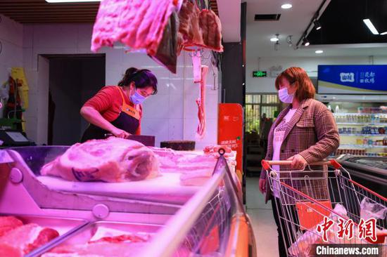 图为市民在超市选购猪肉。　瞿宏伦 摄