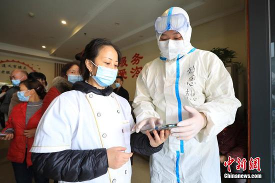 志愿者在新华桥社区老年人日照中心给中心工作人员填写核酸采样资料。 瞿宏伦 摄