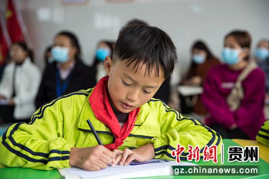 2021年10月22日，贵州省黔西市锦绣街道易地扶贫搬迁安置点锦绣学校，学生填写叶绿素提取报告。