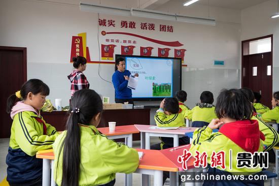 2021年10月22日，贵州省黔西市锦绣街道易地扶贫搬迁安置点锦绣学校，来自北京的教育专家指导学生提取植物叶片中的叶绿素。