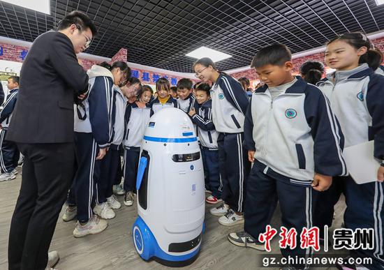 2021年10月29日，在贵州省铜仁市玉屏侗族自治县禁毒宣传教育基地展示馆，学生在听取机器人宣传禁毒知识。