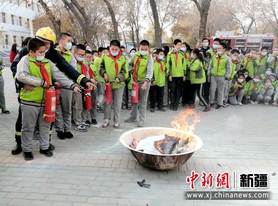 新疆昌吉：消防宣传进校园 师生亲身体验“灭火逃生”