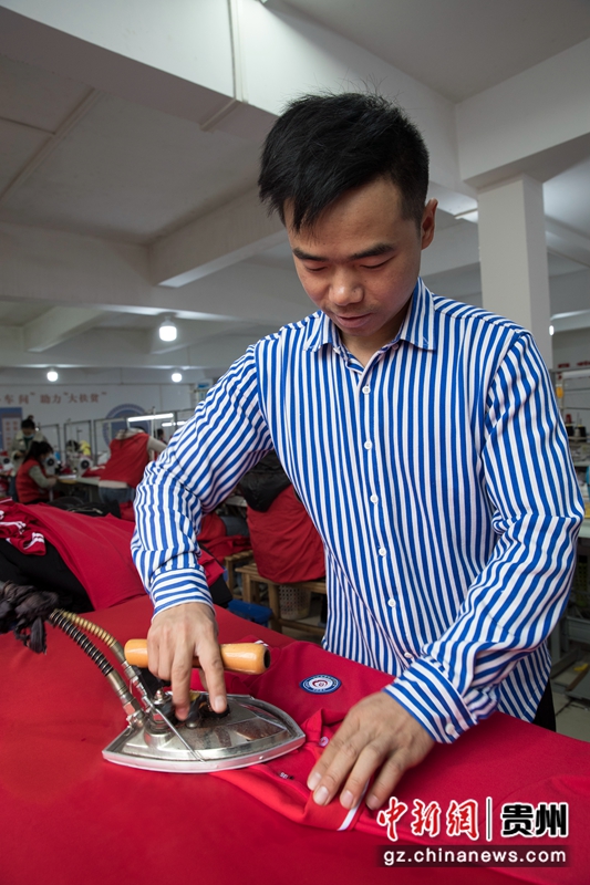 2021年11月2日，贵州省黔西市锦绣花都易地扶贫搬迁安置点内的汇璟服饰加工车间，工人在熨烫服饰。