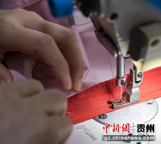 2021年11月2日，贵州省黔西市锦绣花都易地扶贫搬迁安置点内的汇璟服饰加工车间，工人在加工服饰。