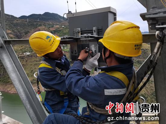 工作人员在220千伏象玉线002号杆塔加装在线监测装置  。陈海摄