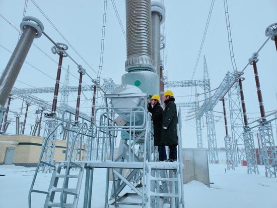 4日，国网新疆电力有限公司检修公司员工如斯太木、郭玉杰在750kV伊犁变电站开展大雪寒潮特巡工作，检查750千伏断路器本体油位、压力情况。刘佳 摄