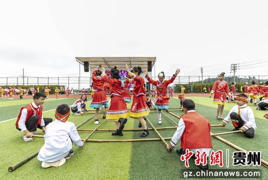贵州省黔西市锦绣学校举行体育艺术文化节，学生在跳竹杆舞。